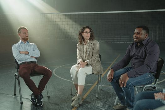 A multicultural group of people participating in a supportive therapy session indoors, fostering diversity and discussion.
